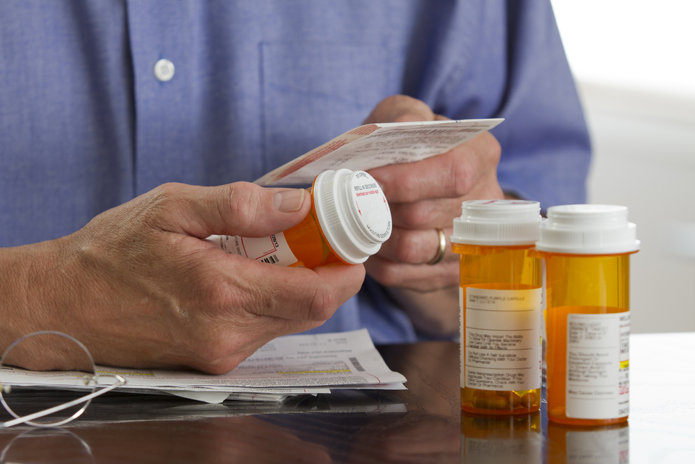 A man checks the hard copy of some medication.